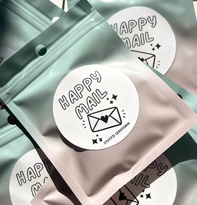 Packaging with 'Happy Mail' labels on a light green background